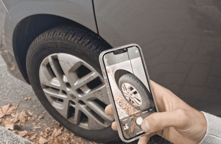 Someone taking photo of car wheel