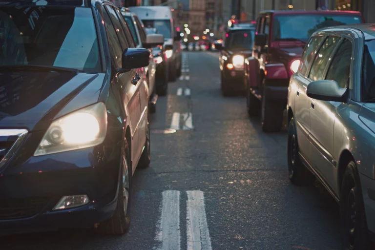 Multiple vehicles lined up in the road in traffic.