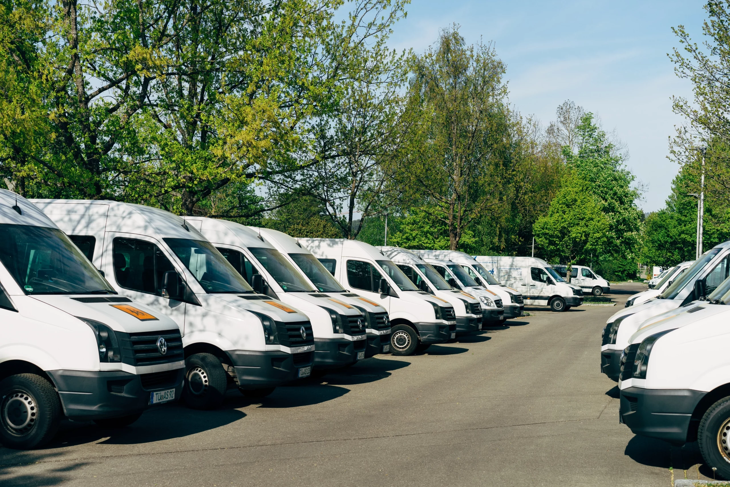 A fleet of vans parked up next to each other in a line.