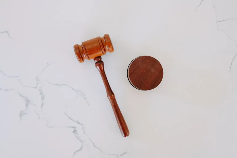 A gavel placed on a white marble background