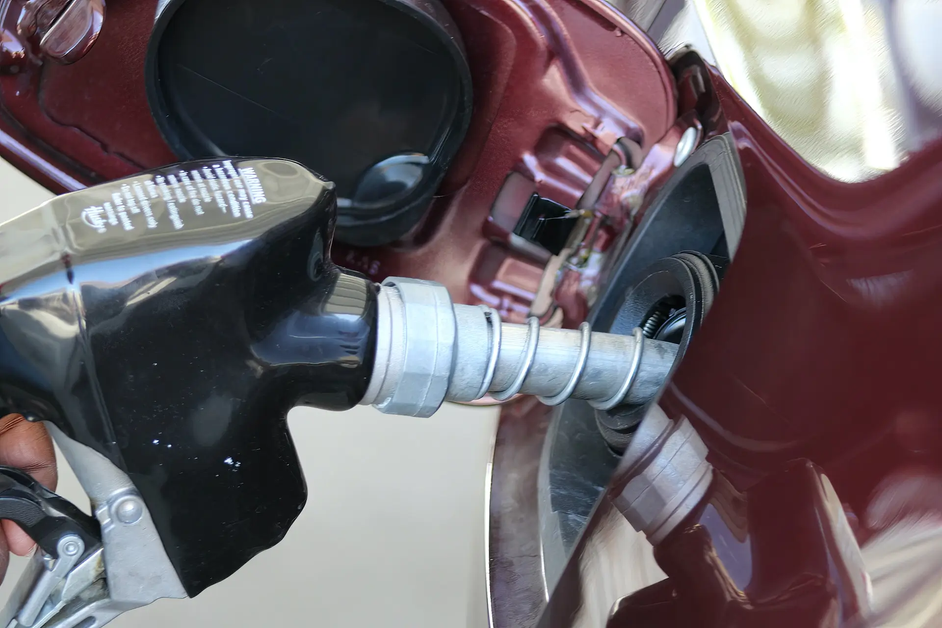 A close up of a person holding a petrol pump